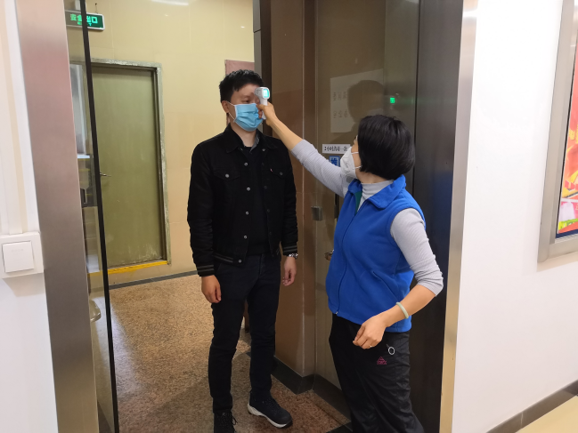 图1 工作人员对到岗干部职工逐一测量体温.jpg